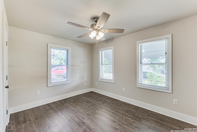 empty room with ceiling fan and dark hardwood / wood-style flooring