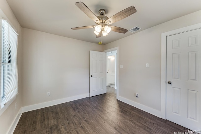 empty room with ceiling fan and dark hardwood / wood-style flooring