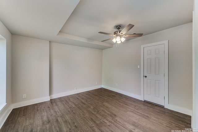 empty room with dark hardwood / wood-style floors and ceiling fan