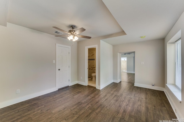 spare room featuring dark hardwood / wood-style floors, ceiling fan, and plenty of natural light