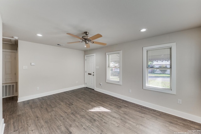 empty room with ceiling fan and dark wood-type flooring