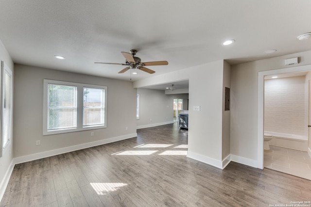 unfurnished living room featuring electric panel, ceiling fan, and hardwood / wood-style flooring