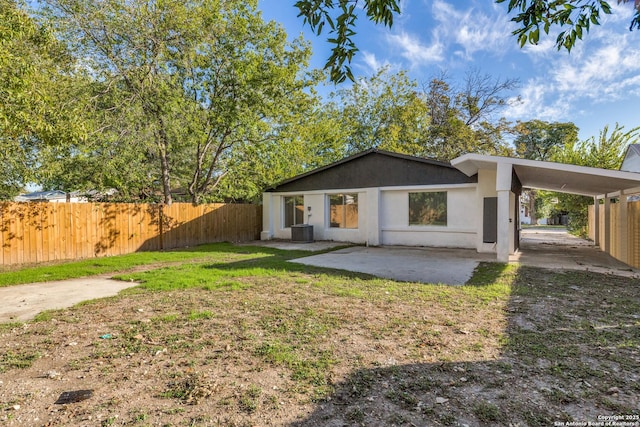 rear view of house featuring a lawn, cooling unit, and a patio