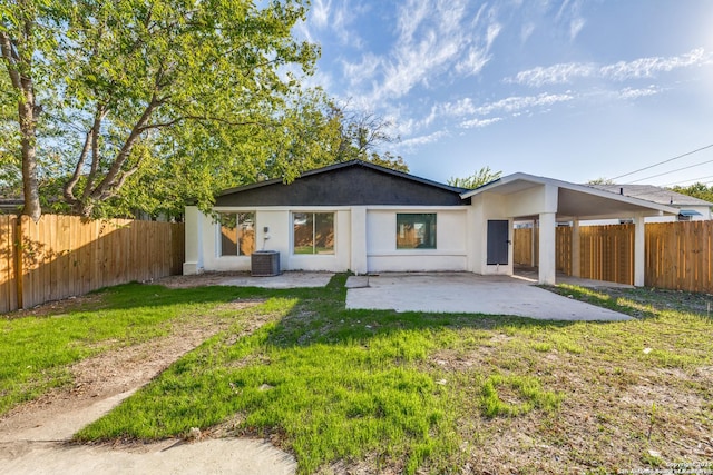 rear view of property featuring a lawn, a patio area, and central air condition unit