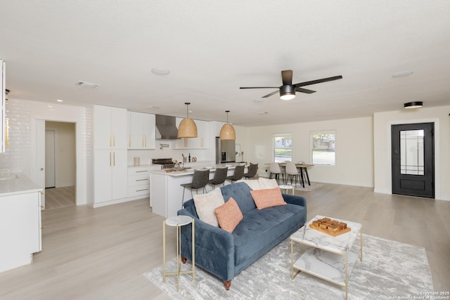 living room featuring ceiling fan and light wood-type flooring