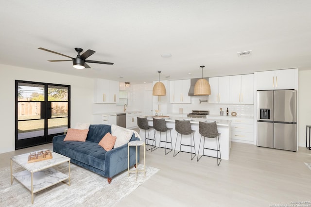 living room featuring ceiling fan and sink