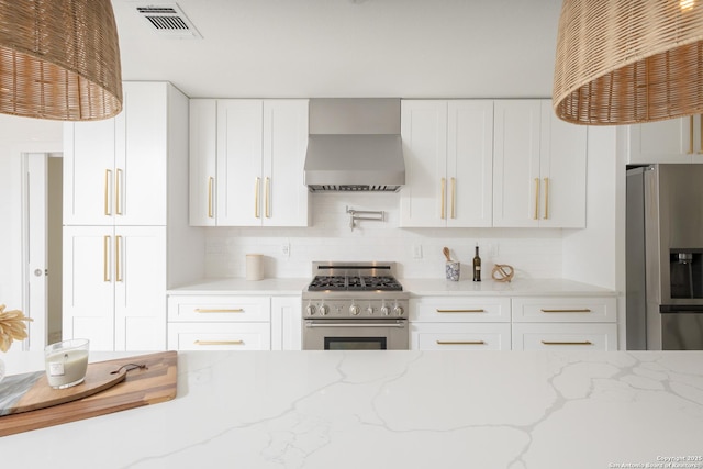 kitchen with white cabinets, light stone countertops, wall chimney exhaust hood, and appliances with stainless steel finishes