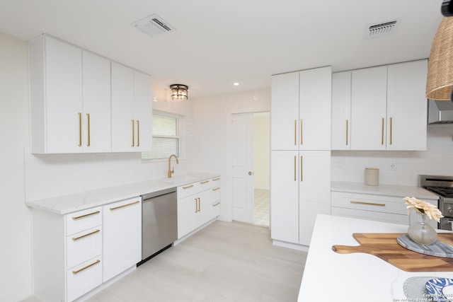 kitchen with decorative backsplash, light stone counters, stainless steel appliances, sink, and white cabinets