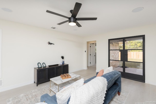 living room featuring french doors, light wood-type flooring, and ceiling fan