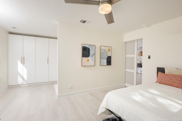 bedroom featuring a closet, light hardwood / wood-style floors, and ceiling fan