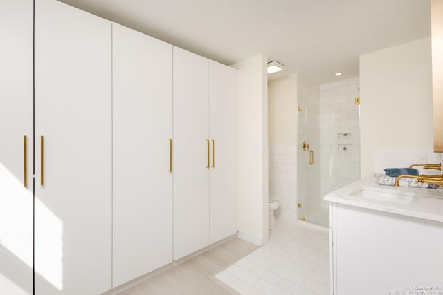 bathroom featuring vanity, toilet, and walk in shower