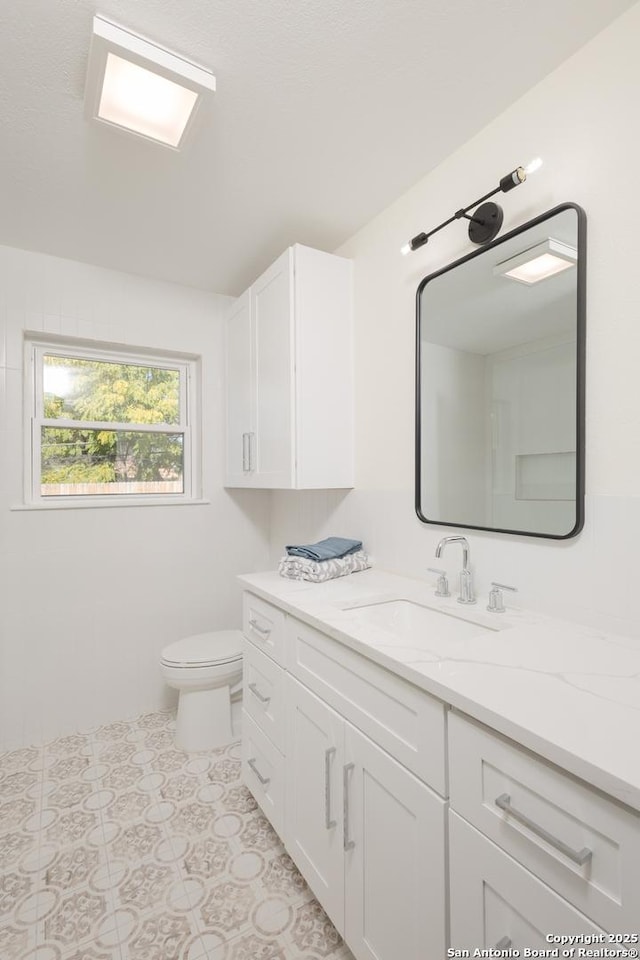 bathroom with tile patterned flooring, vanity, and toilet