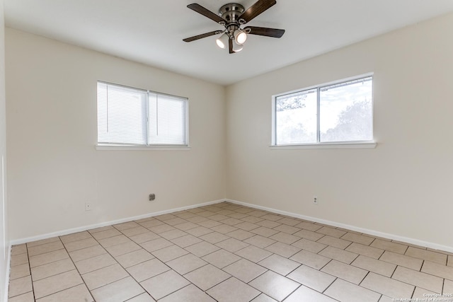 tiled empty room with ceiling fan and a healthy amount of sunlight