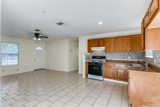 kitchen with decorative backsplash, ceiling fan, sink, light tile patterned floors, and white gas stove