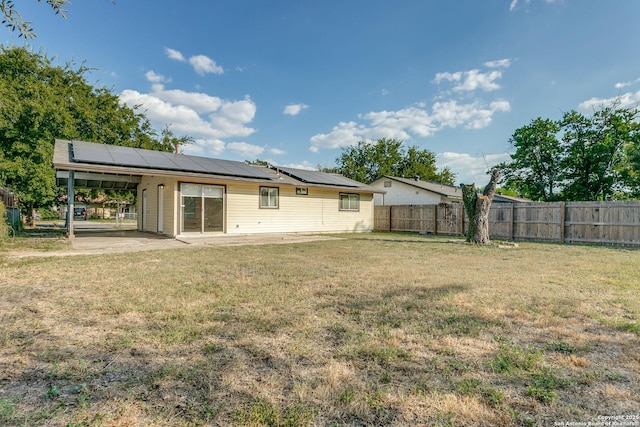 rear view of house with a yard, a patio, and a carport