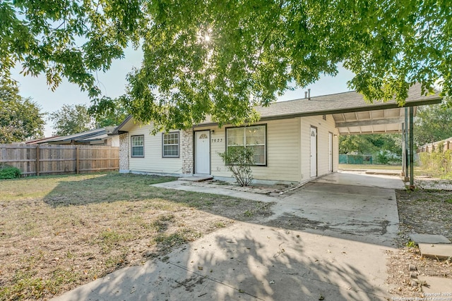 ranch-style home featuring a front lawn and a carport