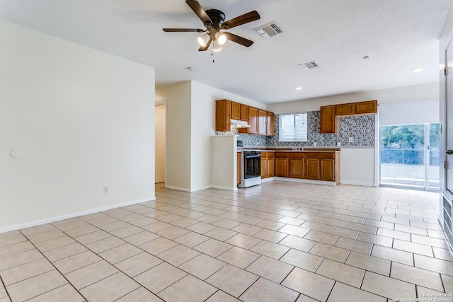 kitchen with decorative backsplash, ceiling fan, stove, and light tile patterned floors