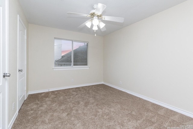 carpeted spare room featuring ceiling fan