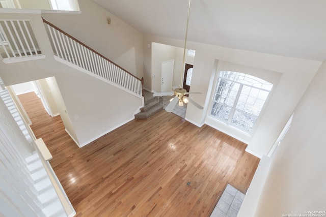 entrance foyer featuring wood-type flooring, a wealth of natural light, and a high ceiling