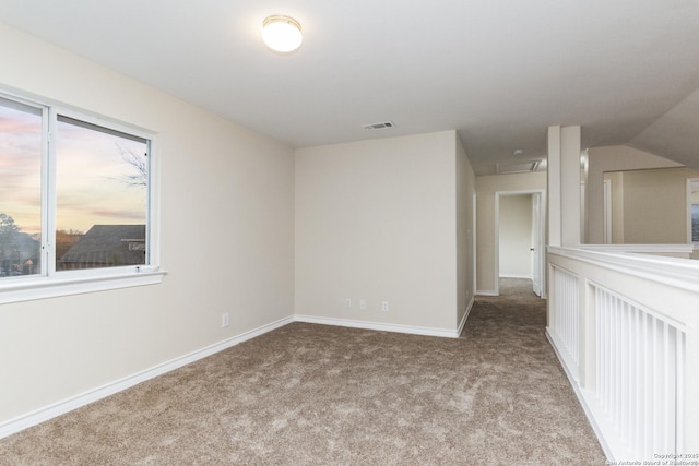 carpeted empty room featuring lofted ceiling