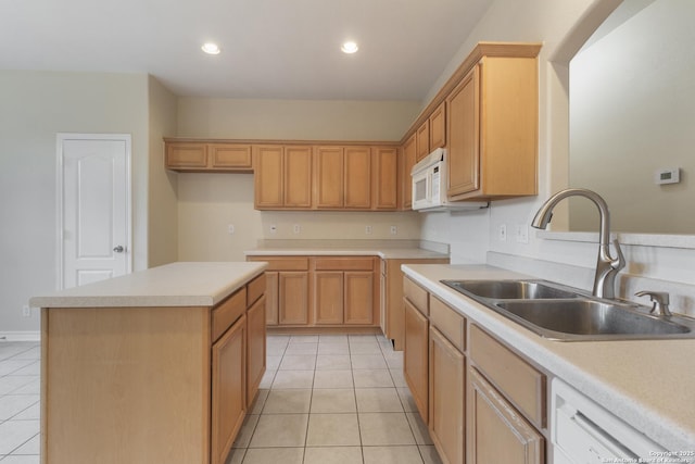 kitchen featuring white appliances, light tile patterned floors, a center island, and sink