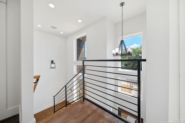 stairs with a notable chandelier and wood-type flooring