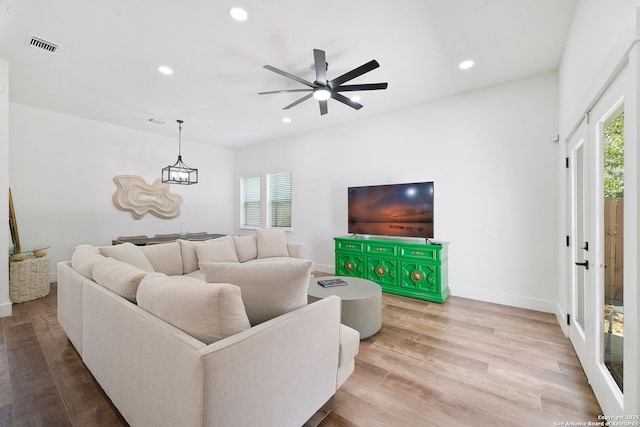 living room featuring hardwood / wood-style floors and ceiling fan with notable chandelier