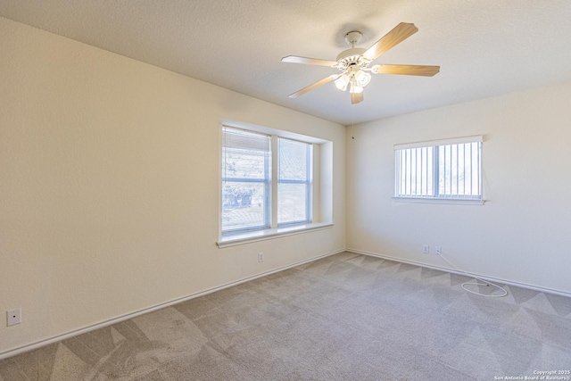 spare room with ceiling fan and light colored carpet