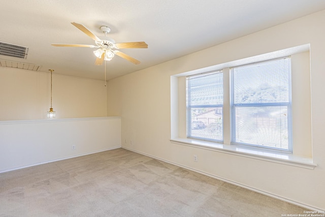 empty room with light colored carpet, plenty of natural light, and ceiling fan