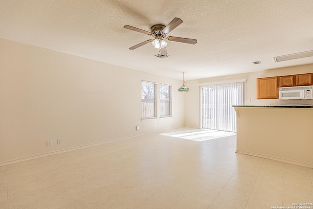 unfurnished living room featuring a textured ceiling and ceiling fan