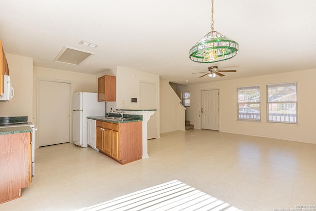 kitchen featuring white appliances, decorative light fixtures, ceiling fan, and sink