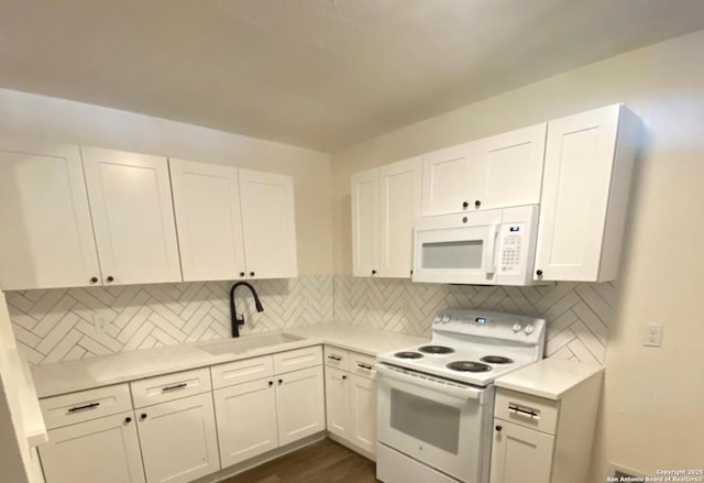 kitchen with decorative backsplash, white appliances, white cabinets, and sink