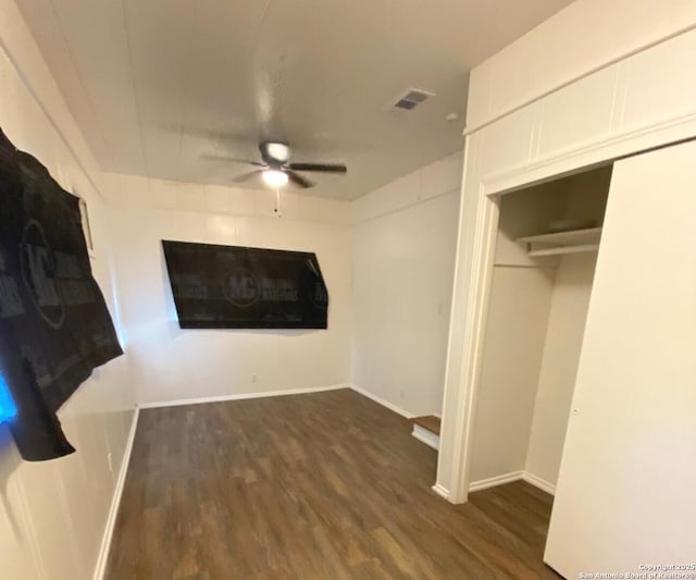 unfurnished bedroom featuring ceiling fan, dark hardwood / wood-style flooring, and a closet