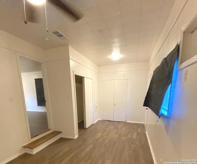 unfurnished bedroom featuring ceiling fan and dark wood-type flooring