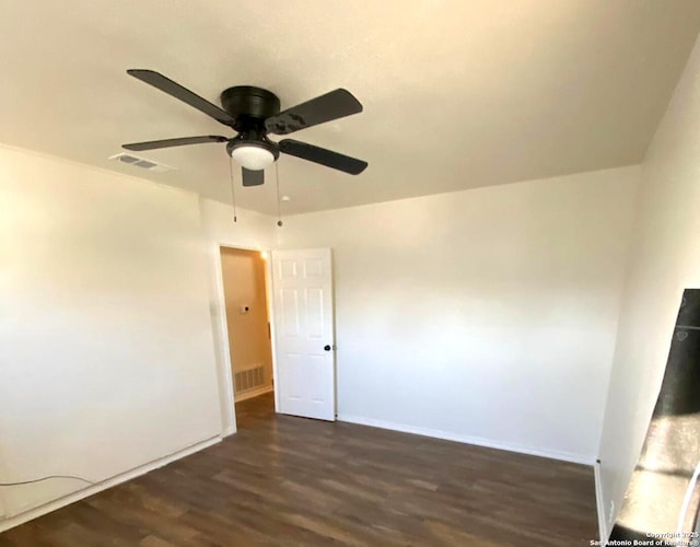 unfurnished room with ceiling fan and dark wood-type flooring