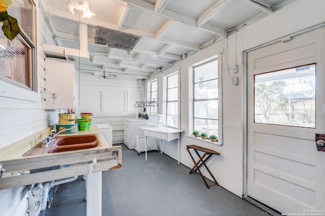 interior space featuring sink, white cabinets, and concrete flooring