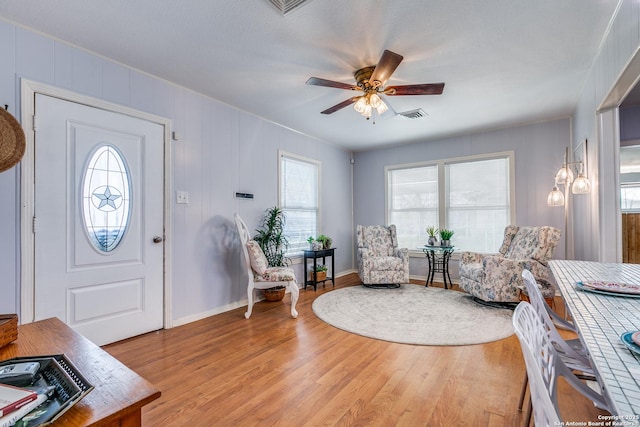 foyer with a wealth of natural light, light wood-type flooring, and ceiling fan