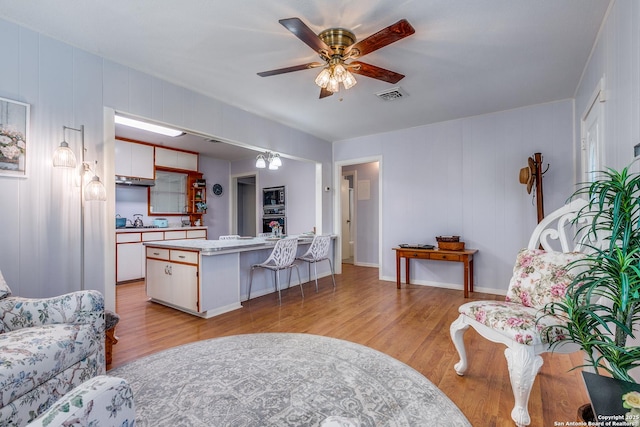 living room featuring ceiling fan and light hardwood / wood-style flooring