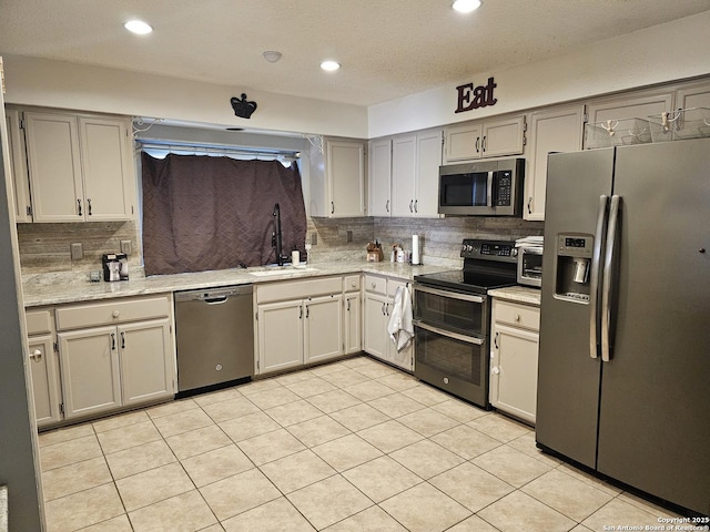 kitchen with sink, stainless steel appliances, tasteful backsplash, gray cabinets, and light tile patterned floors