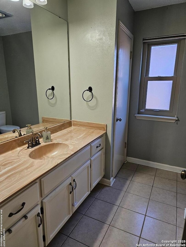 bathroom featuring tile patterned floors, vanity, and toilet