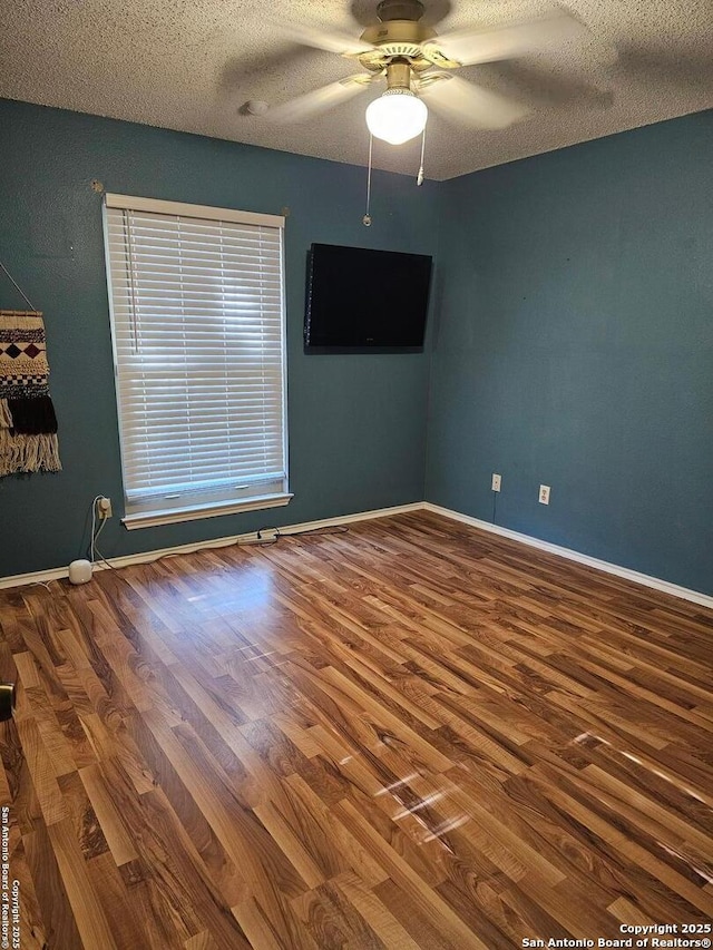 empty room with hardwood / wood-style floors, a textured ceiling, and ceiling fan