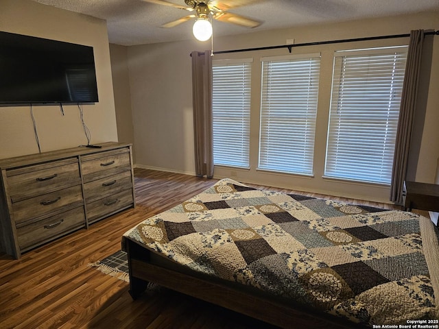 bedroom featuring ceiling fan, dark wood-type flooring, and a textured ceiling