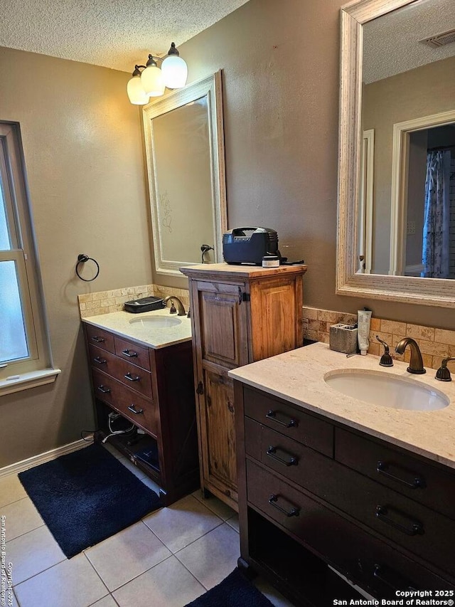 bathroom featuring tile patterned floors, vanity, and a textured ceiling