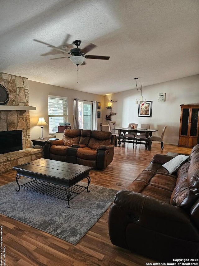 living room featuring a fireplace, dark hardwood / wood-style flooring, and a textured ceiling