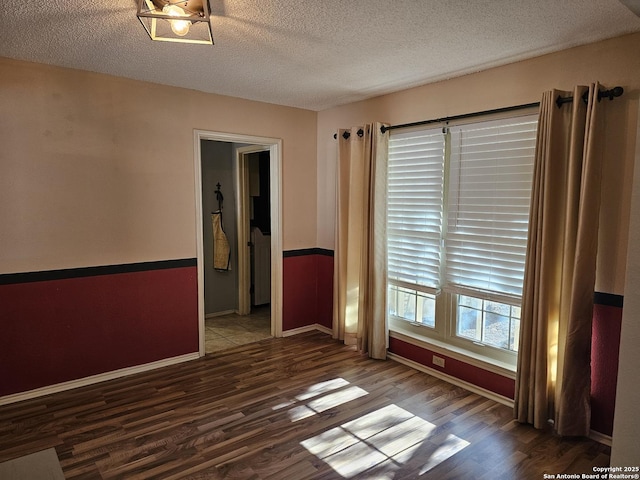 unfurnished room with hardwood / wood-style floors and a textured ceiling