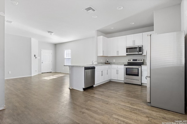 kitchen featuring white cabinetry, hardwood / wood-style floors, sink, and appliances with stainless steel finishes