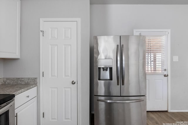 kitchen with white cabinetry, stainless steel appliances, and light hardwood / wood-style floors