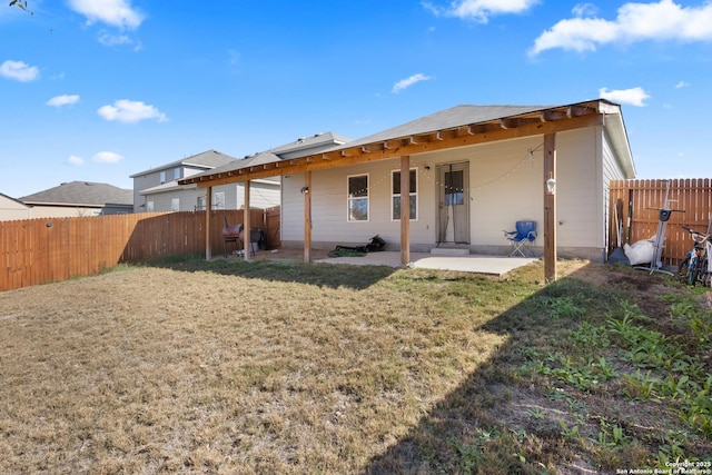 rear view of property with a yard and a patio