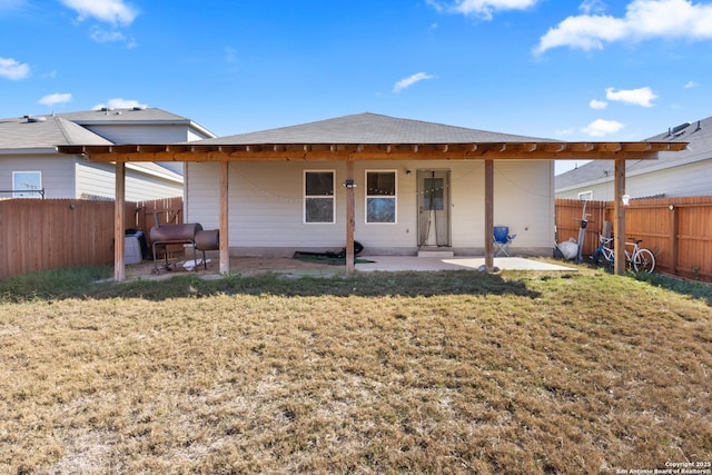 back of property with a patio area and a yard