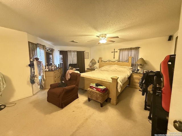 carpeted bedroom featuring ceiling fan and a textured ceiling